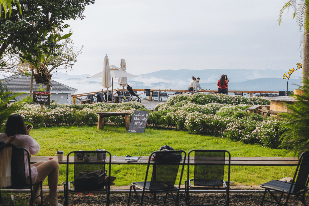 Quán trang trí theo phong cách đậm chất thiên nhiên với nhiều tiểu cảnh như xích đu gỗ, hoa tươi (Nguồn: Fanpage Tiệm cà phê Trên Đồi Có Mây)